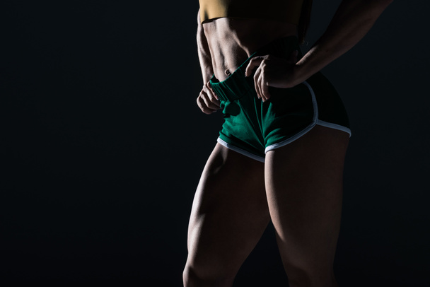 vue partielle du bodybuilder avec les jambes musclées, isolé sur noir
    - Photo, image