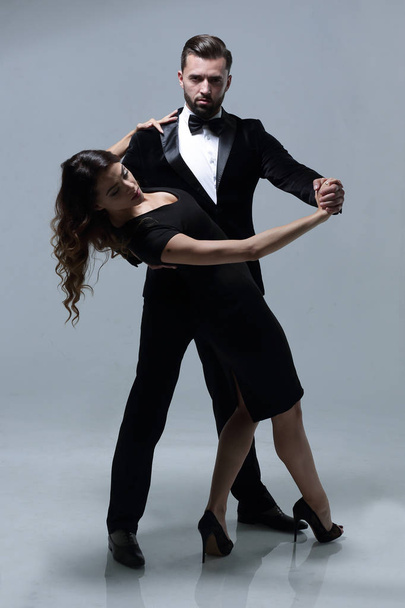 Portrait Of Young Couple Dancing Over Grey Background - Fotografie, Obrázek