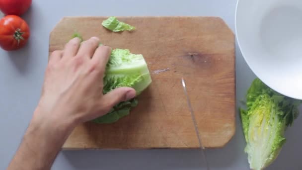 Chef hands peel salad on wooden cutting board - Кадры, видео