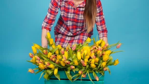 Mladé samice květinářství s velkou krabici žlutých tulipánů - Záběry, video