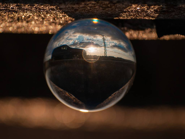 Spiegelungen des Sonnenuntergangs in der Stadt in einem Kristallkugel / Umwelt-Konzept - Foto, Bild