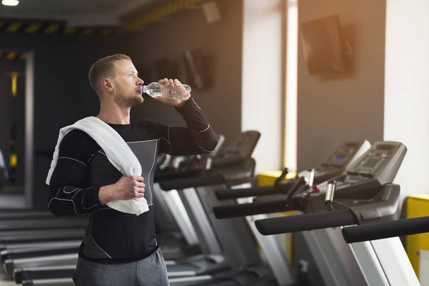 Männlicher Bodybuilder trinkt nach dem Training Wasser - Foto, Bild