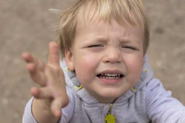 Smutny płaczące dziecko podciąga ręce. Portret chłopca, prosząc o pick up z bliska - Zdjęcie, obraz