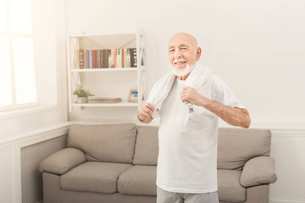 Veselý starší muž v oblečení s ručníkem - Fotografie, Obrázek