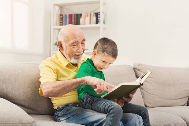Ανώτερος άνθρωπος διαβάζοντας το βιβλίο για το εγγόνι του - Φωτογραφία, εικόνα