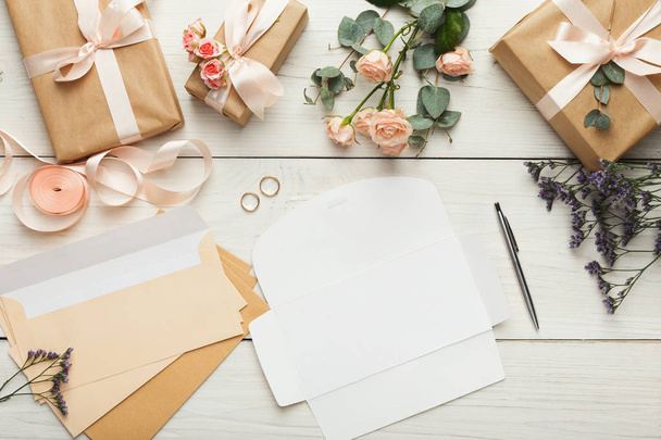 Bruiloft uitnodigingskaarten en enveloppen op witte houten tafel, te - Foto, afbeelding