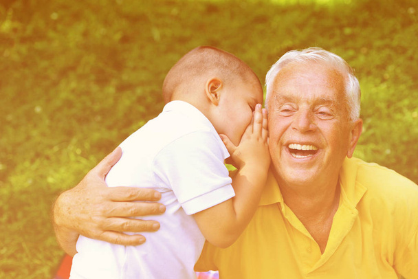 szczęśliwy dziadek i dziecko bawić się i bawić w parku w piękny słoneczny dzień - Zdjęcie, obraz
