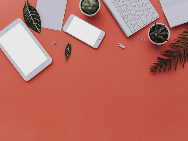 Espace de travail créatif avec tablette, téléphone, clavier et feuilles tropicales. Vue du dessus, espace de copie. Pose plate
  - Photo, image