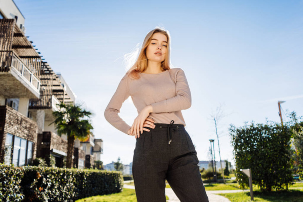 stylish young blonde model girl posing outdoors in the sun - Fotó, kép