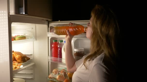 Woman opens the refrigerator at night. night hunger. diet. gluttony, 4k - Video