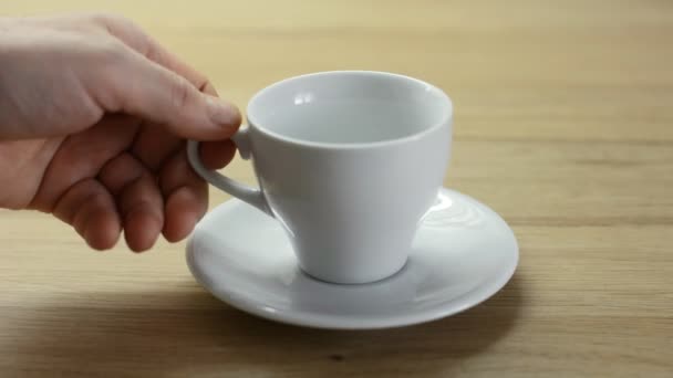 Hand pours boiling water into a white cup. Chocolate muffins for dessert and coffee - Кадры, видео