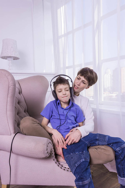 Mãe gritando para seu filho enquanto ele escuta música e não ouve
 - Foto, Imagem