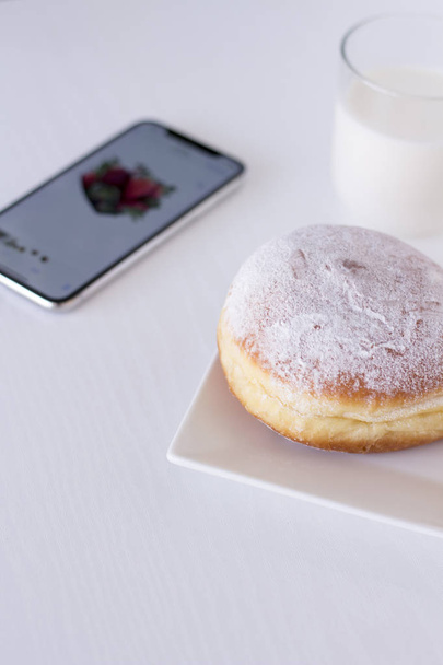 Doughnuts and phone on white background morning routine - Fotó, kép