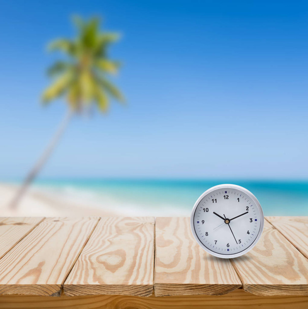 clock on wood table and blue sea background - Foto, imagen