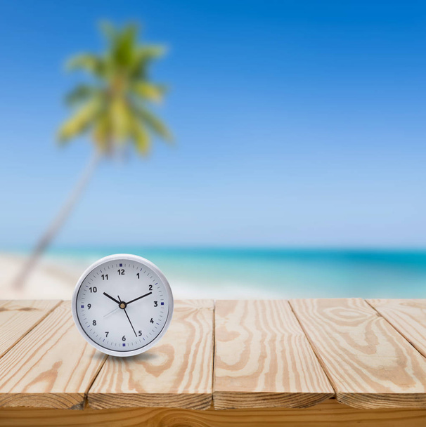 Clock on wood table and blue sea background - Fotografie, Obrázek