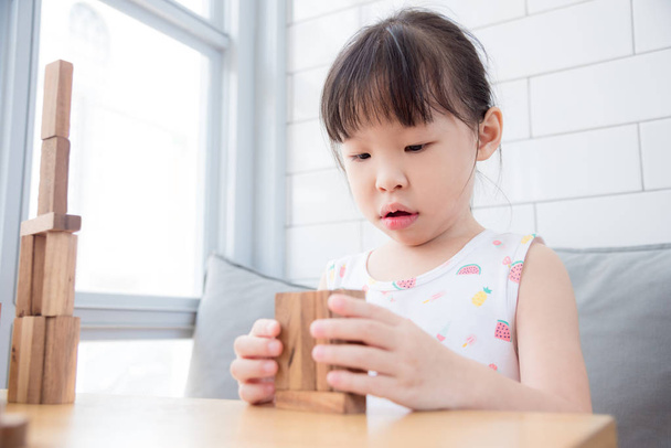 chica jugando bloques de madera en casa
 - Foto, Imagen