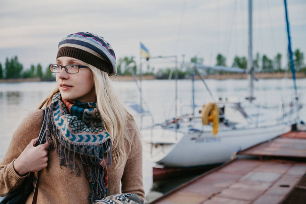 slender blonde in beret stands next to yacht - Foto, immagini