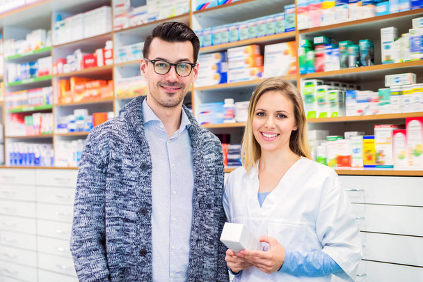 Portrait of female pharmacist with a male customer. - Photo, Image