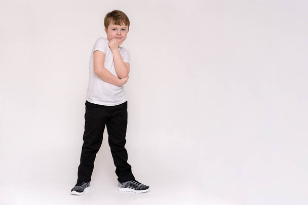 cute boy aged 6 years shows on a white background in different poses different emotions - Zdjęcie, obraz