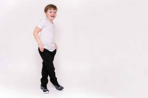 cute boy aged 6 years shows on a white background in different poses different emotions - Фото, изображение