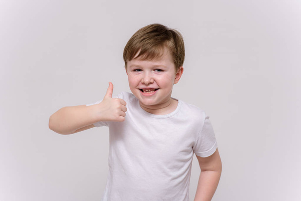 cute boy aged 6 years shows on a white background in different poses different emotions - 写真・画像