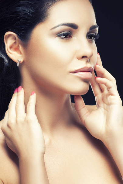 Portrét ženy bruneta s přírodní make-up a rukama poblíž tvář na černém pozadí - Fotografie, Obrázek