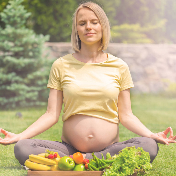 Pregnant woman practicing meditation and relaxation in nature - Foto, Bild