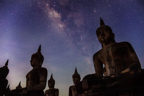 Milky way galaxy with buddha stature landscape nature dark filter style - Photo, Image