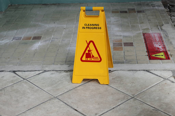 Keltainen varovaisuus puhdistus edistystä merkki lattialla ulkona
 - Valokuva, kuva