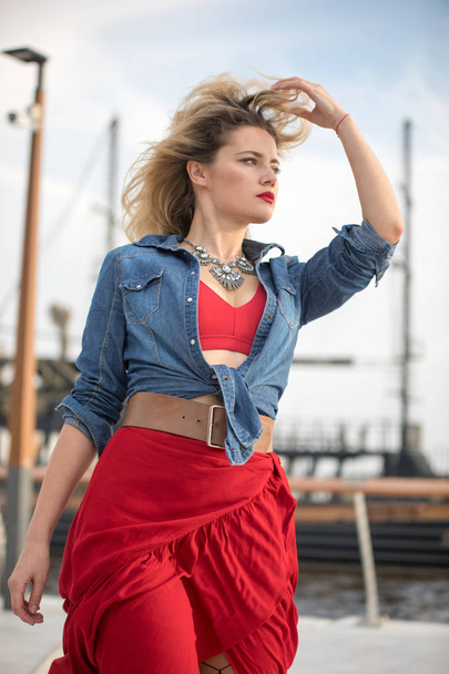 Beautiful woman in a red dress on a ship background. - Foto, imagen