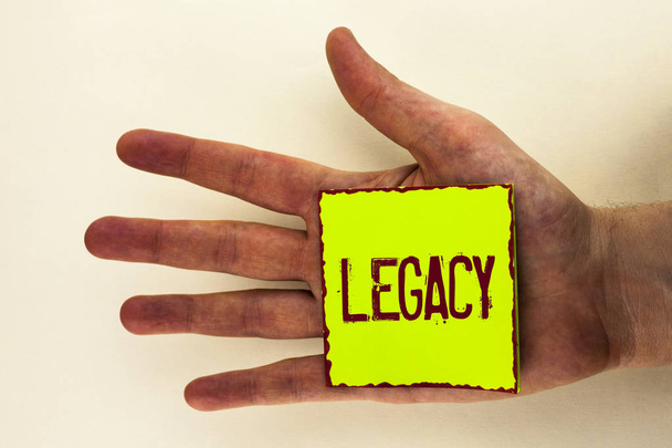 Word writing text Legacy. Business concept for Transmitted Received from an ancestor Money Properties given by will written on Sticky Note Paper placed on the Hand on the plain background. - Photo, Image