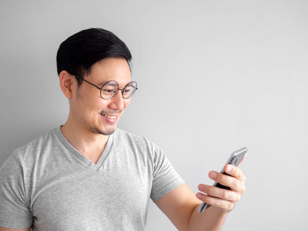 Happy man is using smartphone. Concept of using social media on  - Фото, изображение