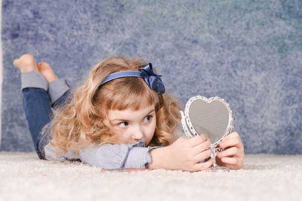 cute  little girl with mirror in studio - Fotó, kép