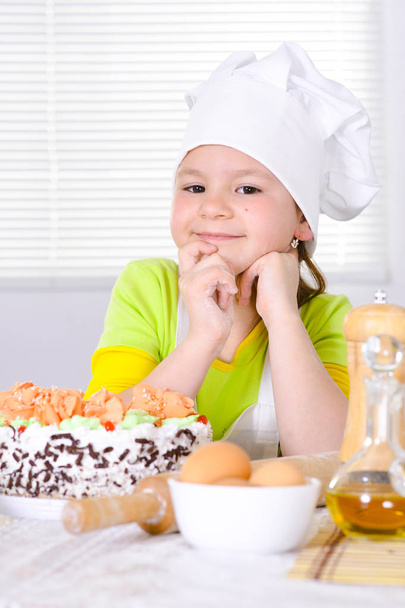 Cute girl baking cake in the kitchen at home - Фото, изображение