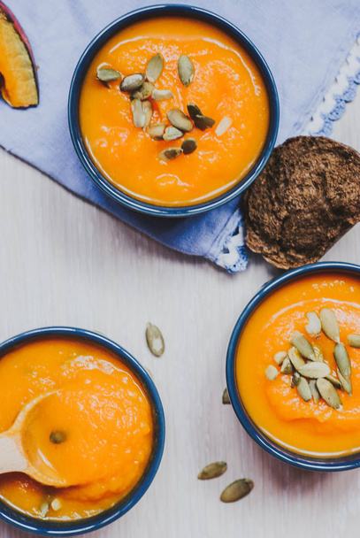 Roasted pumpkin soup with pumpkin seeds on wooden background. - Photo, Image