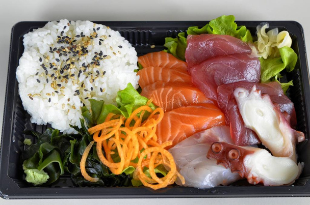 Sashimi con atún rojo, salmón, amberjack, pulpo. Como planta vegetal algas marinas, ensalada, zanahoria, jengibre. Sazonador wasabi, salsa de soja
. - Foto, Imagen