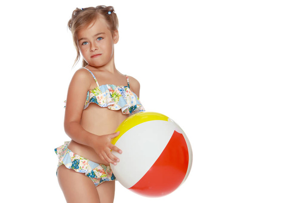 Little girl in a swimsuit with a ball - Fotó, kép