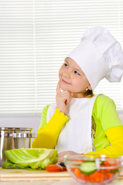 girl wearing chef uniform cooking on kitchen  - Foto, afbeelding