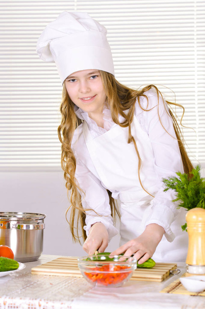 beautiful  girl wearing chef uniform cooking on kitchen  - Fotografie, Obrázek