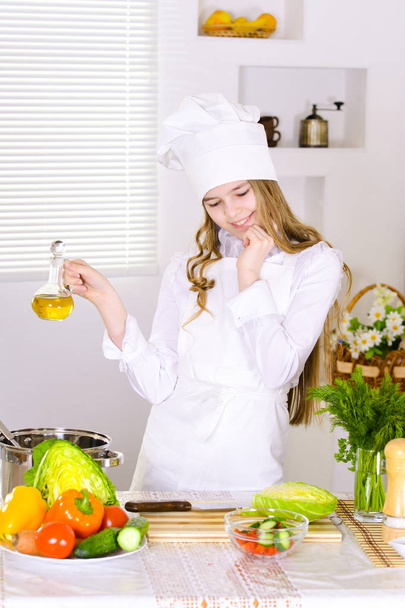 girl wearing chef uniform cooking on kitchen  - Fotó, kép