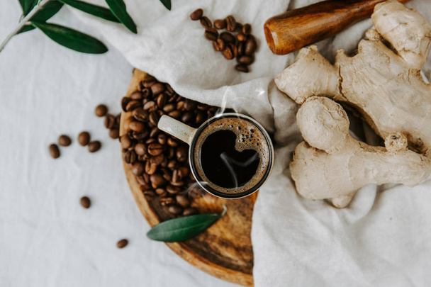 Fresh Turkish coffee in a cup with ginger on linen table. Rural rustic scene. Top view  - Fotoğraf, Görsel