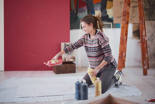 Vrouw kunstenaar schilderen op de verdieping - Foto, afbeelding