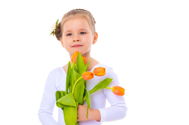 Little girl with a bouquet of tulips. - Φωτογραφία, εικόνα