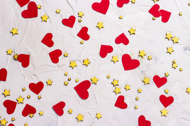 Many small stars and red hearts on a light stone background. Con - Photo, Image