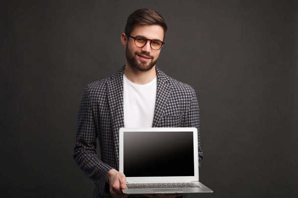 Handsome man selling laptop - Фото, изображение