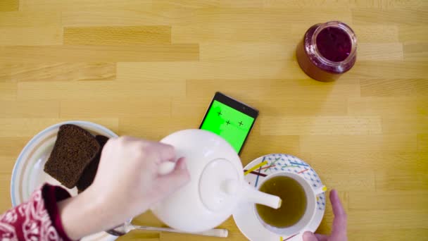 Green screen. Female hands scrolling smart phone - Felvétel, videó