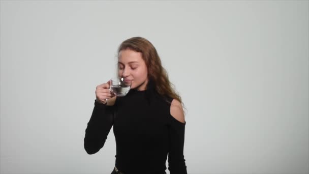 Young beautiful woman drinking water, white background - Metraje, vídeo