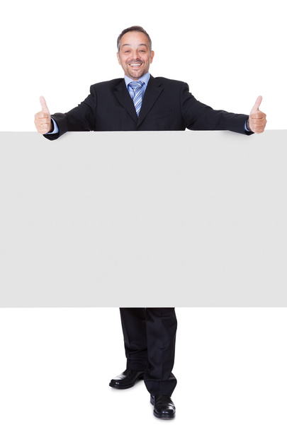 Heureux homme d'affaires tenant le panneau d'affichage blanc
 - Photo, image