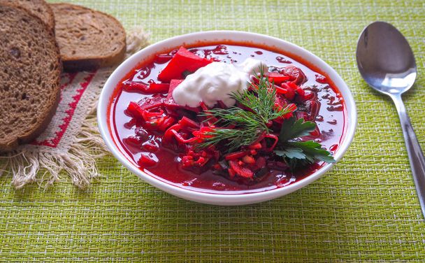 Boršč – polévka z řepy v bílé míse na dřevěné pozadí, tradiční pokrm z ukrajinské kuchyně. Pohled shora. - Fotografie, Obrázek