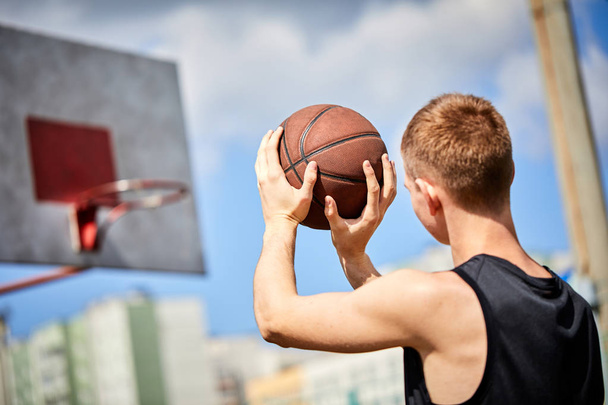 man met bal terwijl het spelen van basketbal outdoor - Foto, afbeelding